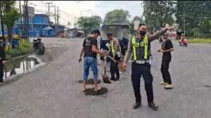 Personel Polsek Krian Gerak Cepat Tangani Jalan Berlubang Demi Keselamatan Pengguna Jalan